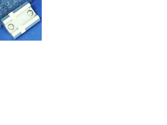 Silver metal component with screws on blue surface.