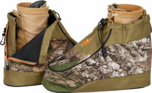 Camouflage hunting boots with zippered openings.