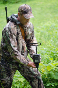 Hunter setting up a trail camera in the woods.