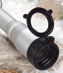 Silver telescope on snowy ground with open lens cap.