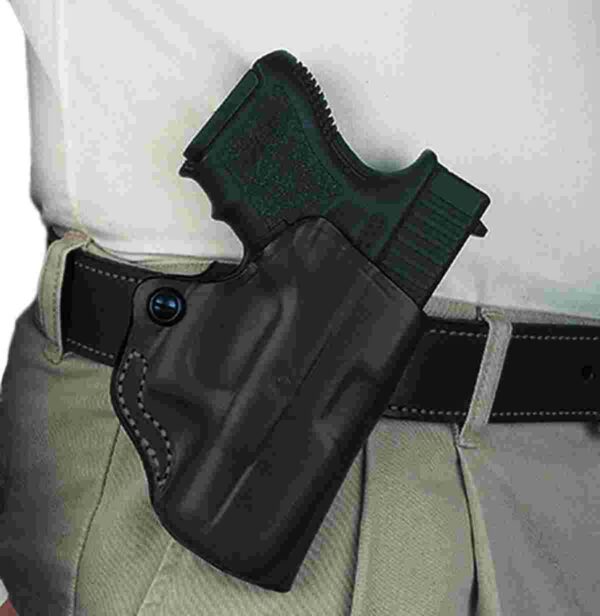 Holstered handgun in waist holster.