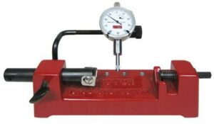 Red dial indicator gauge on metal fixture.