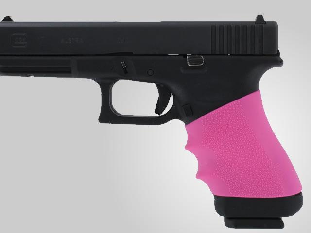 Handgun with pink grip isolated on grey background.