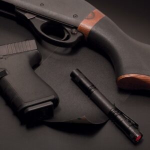 Handgun, flashlight, and shotgun on dark background.