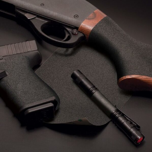 Flashlight and firearms on black surface