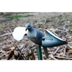 Plastic bird decoy on post in outdoor setting.
