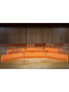 Orange ammo trays holding bullets on wooden surface.
