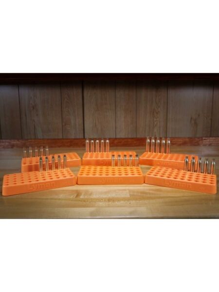 Orange ammo trays holding bullets on wooden surface.