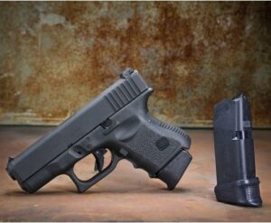 Handgun and magazine on rustic background.