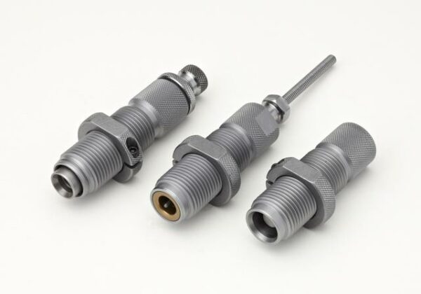 Three metallic machine parts on white background.