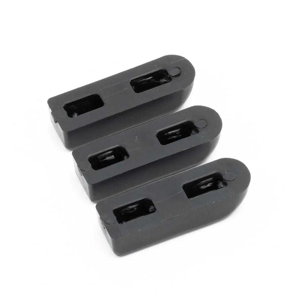 Three black rubber door stoppers aligned.