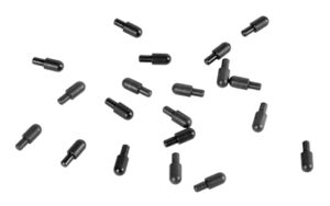 Scattered black plastic dowel pins on white background.