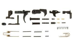 Disassembled firearm trigger assembly parts on white background