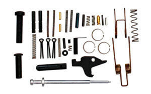 Assorted gun parts and springs laid on white background.