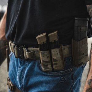 Person wearing tactical belt with magazine pouches.