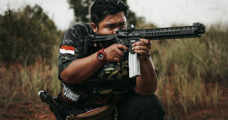 Shooter aiming an AR-15 rifle at an outdoor shooting range