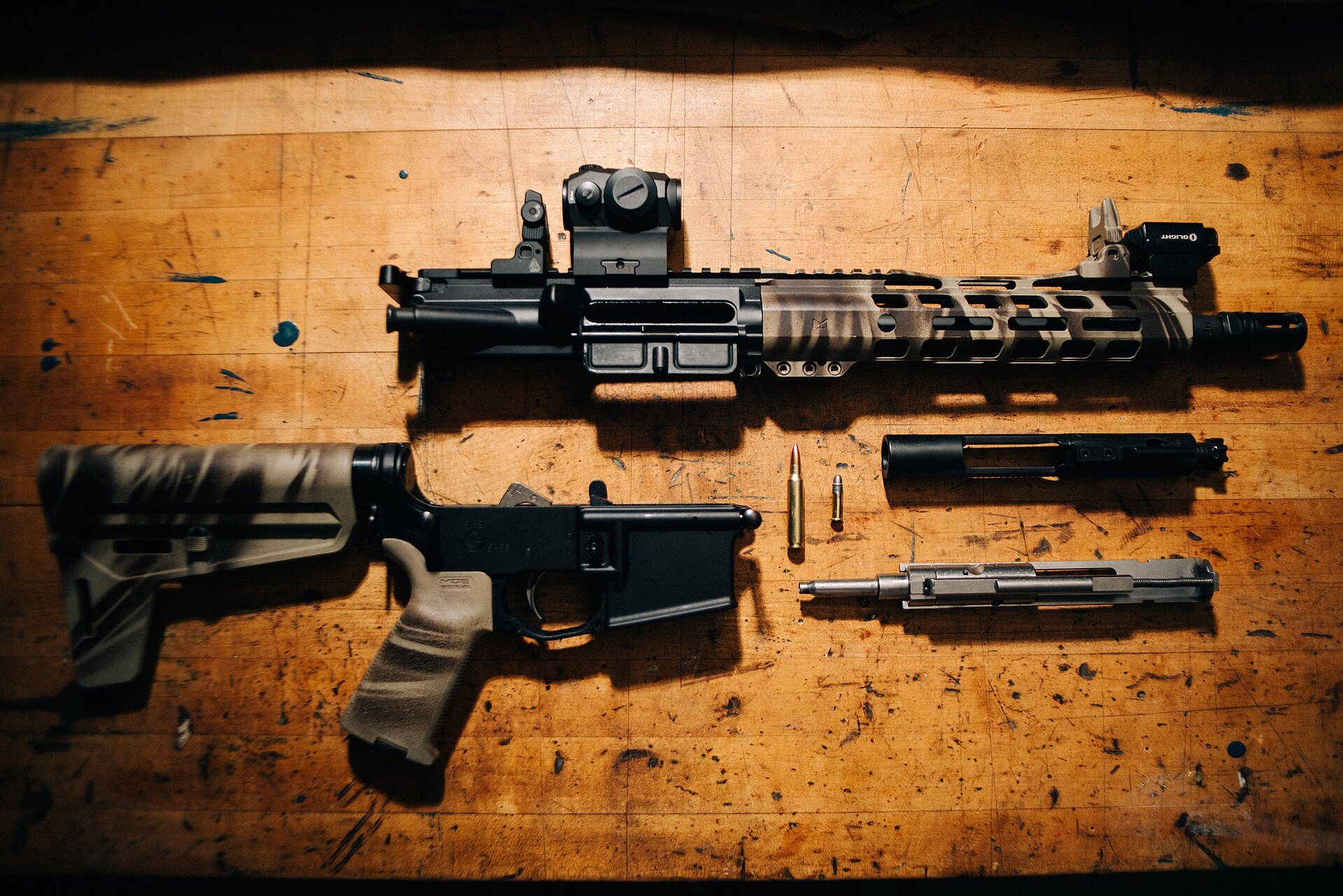 Disassembled AR-15 style pistol on a workbench
