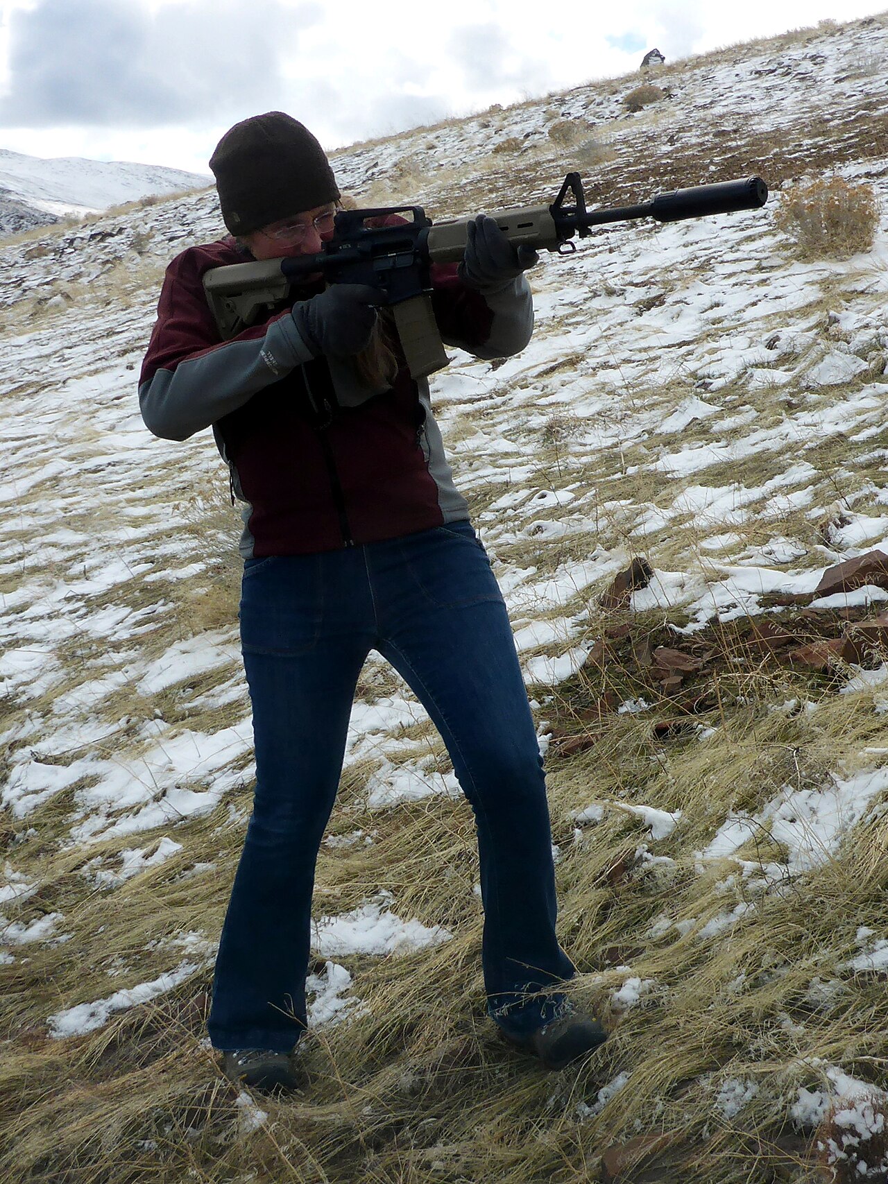 Person holding a suppressed AR-15 rifle